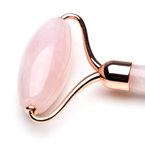 A close up image of the BK Beauty Face the Day rose quartz face roller on a white background